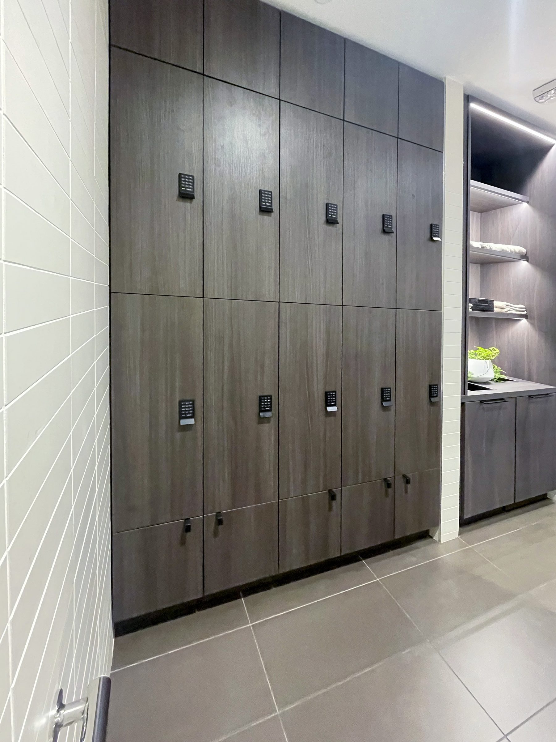 Dark espresso woodgrain lockers in a wellness spa locker room with white tile