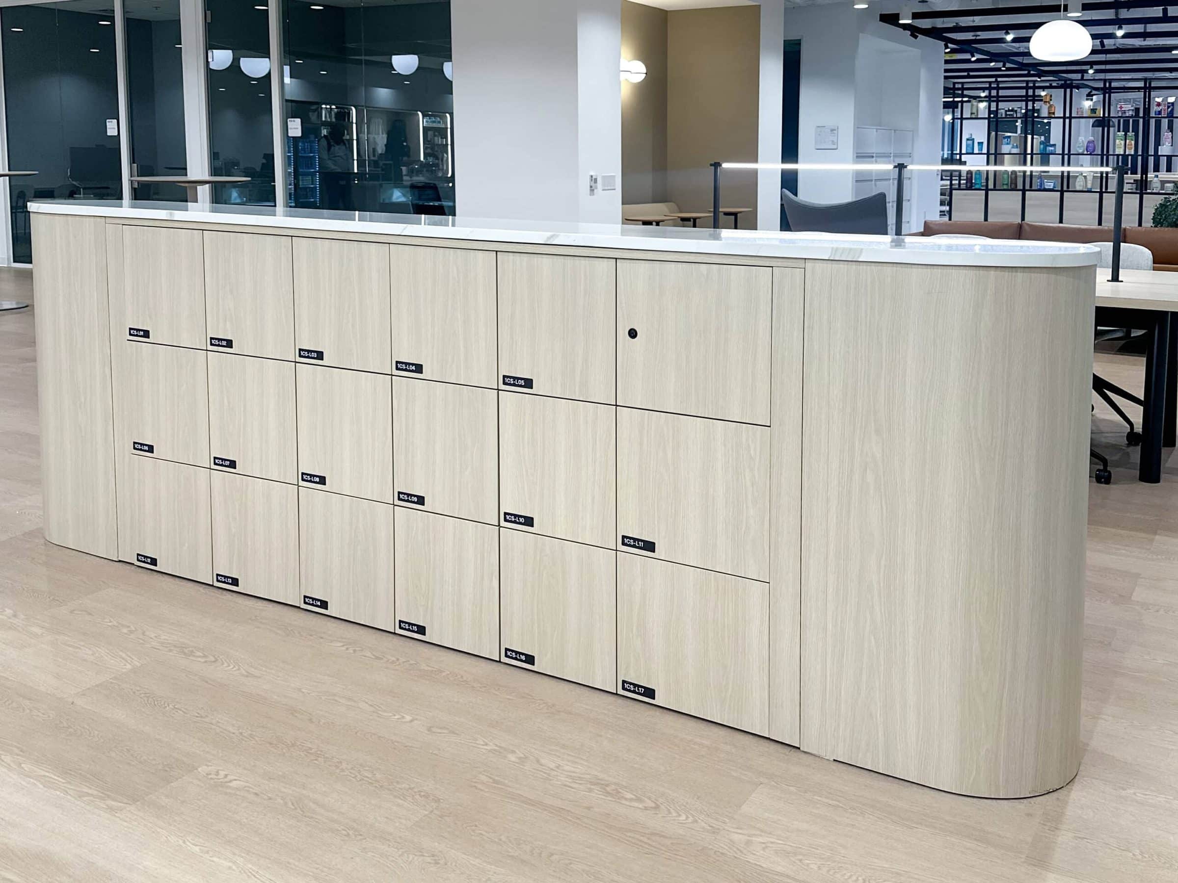 Light ash woodgrain locker island with rounded corners and quartz top
