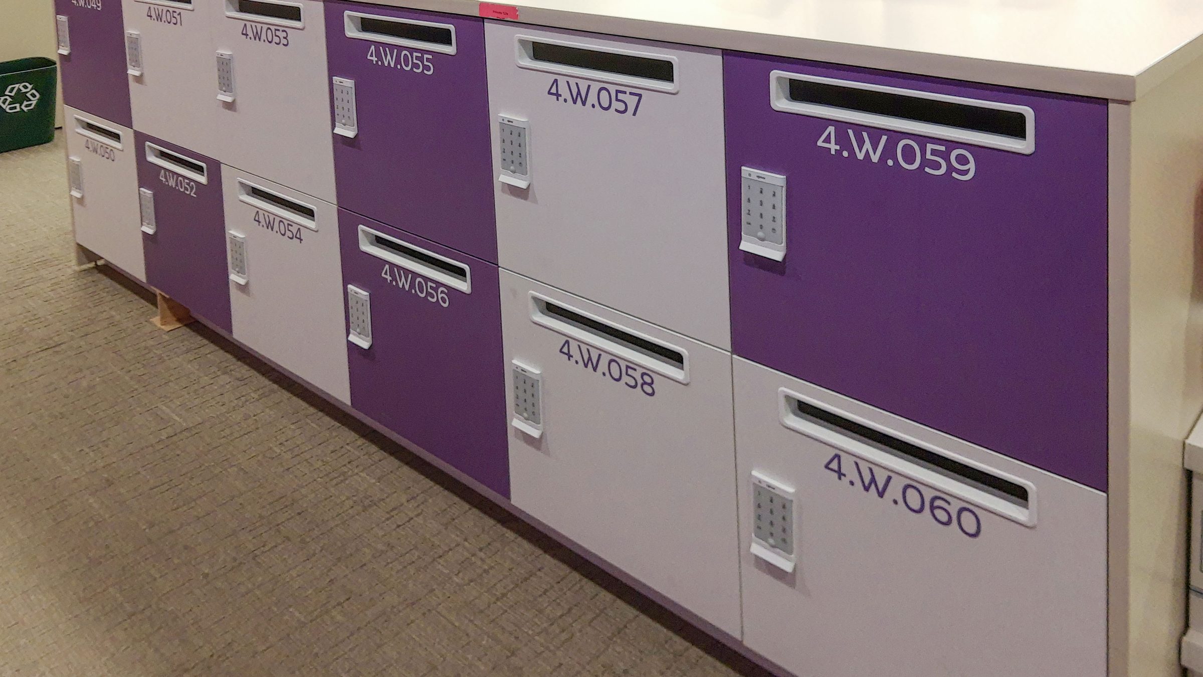 Purple branded locker island with mail slots — corporate workplace