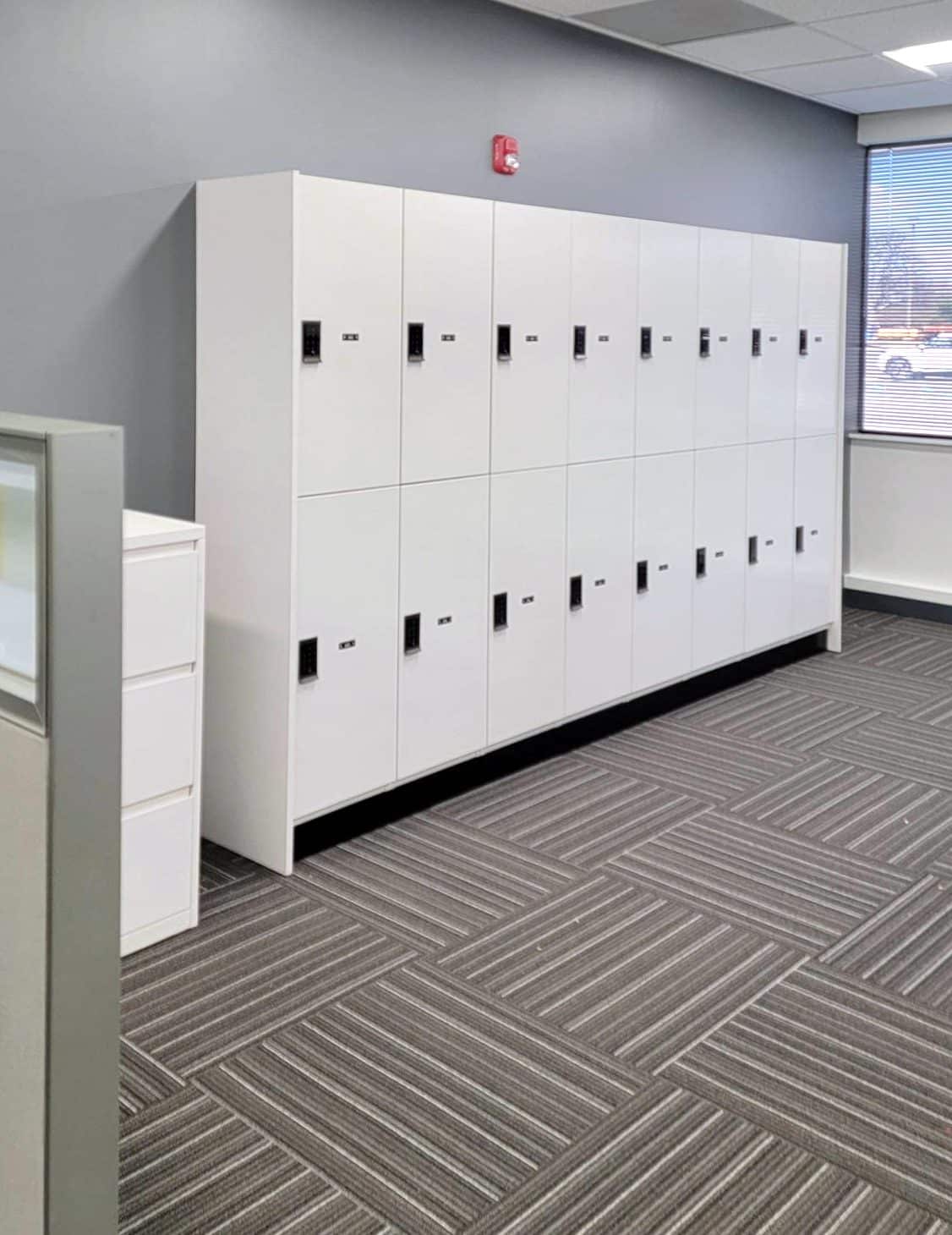White 2-tier lockers alongside cubicle workstations in a corporate NYC office