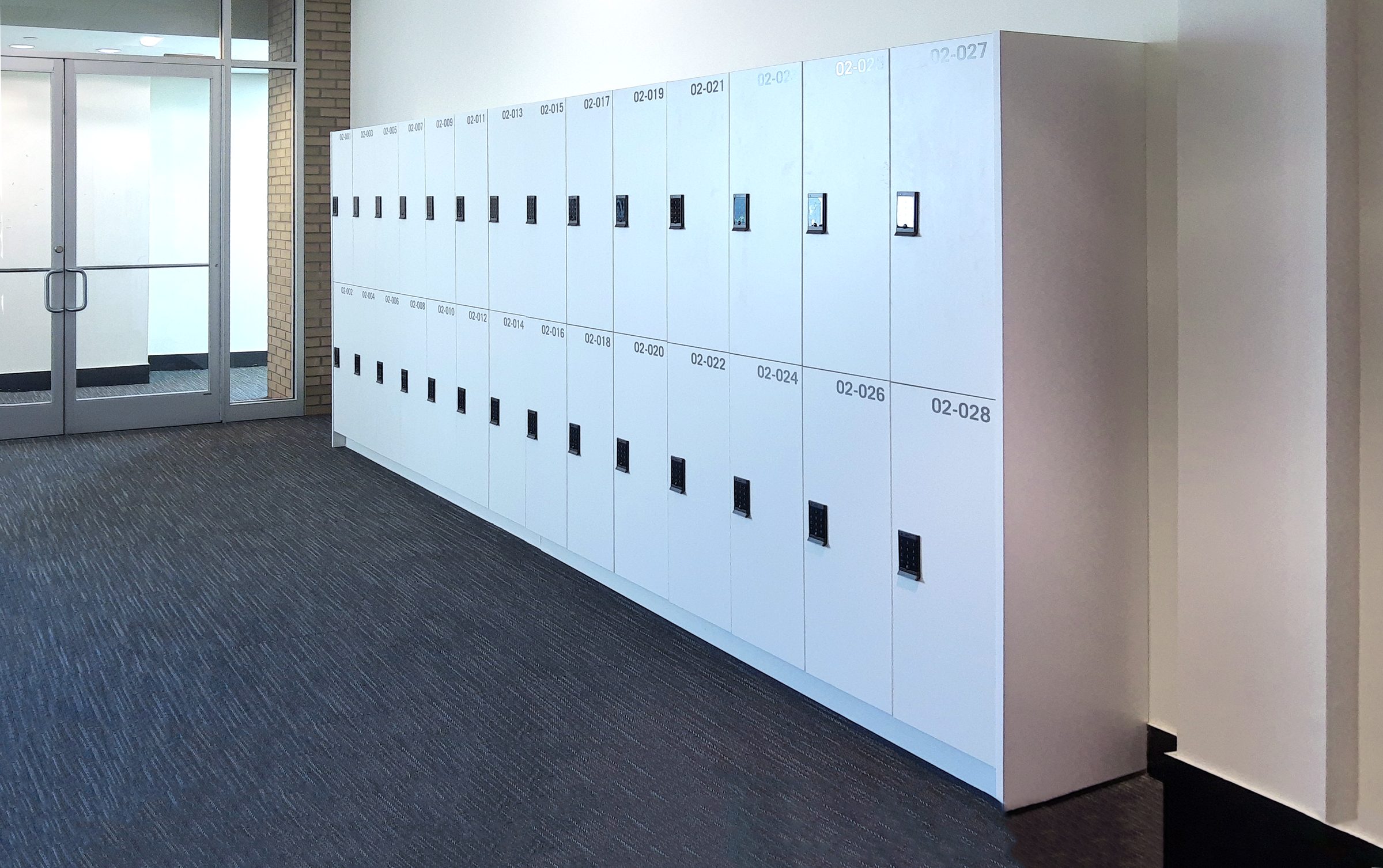 White 2-tier laminate lockers lining a corporate corridor — showing clean HPL surface quality