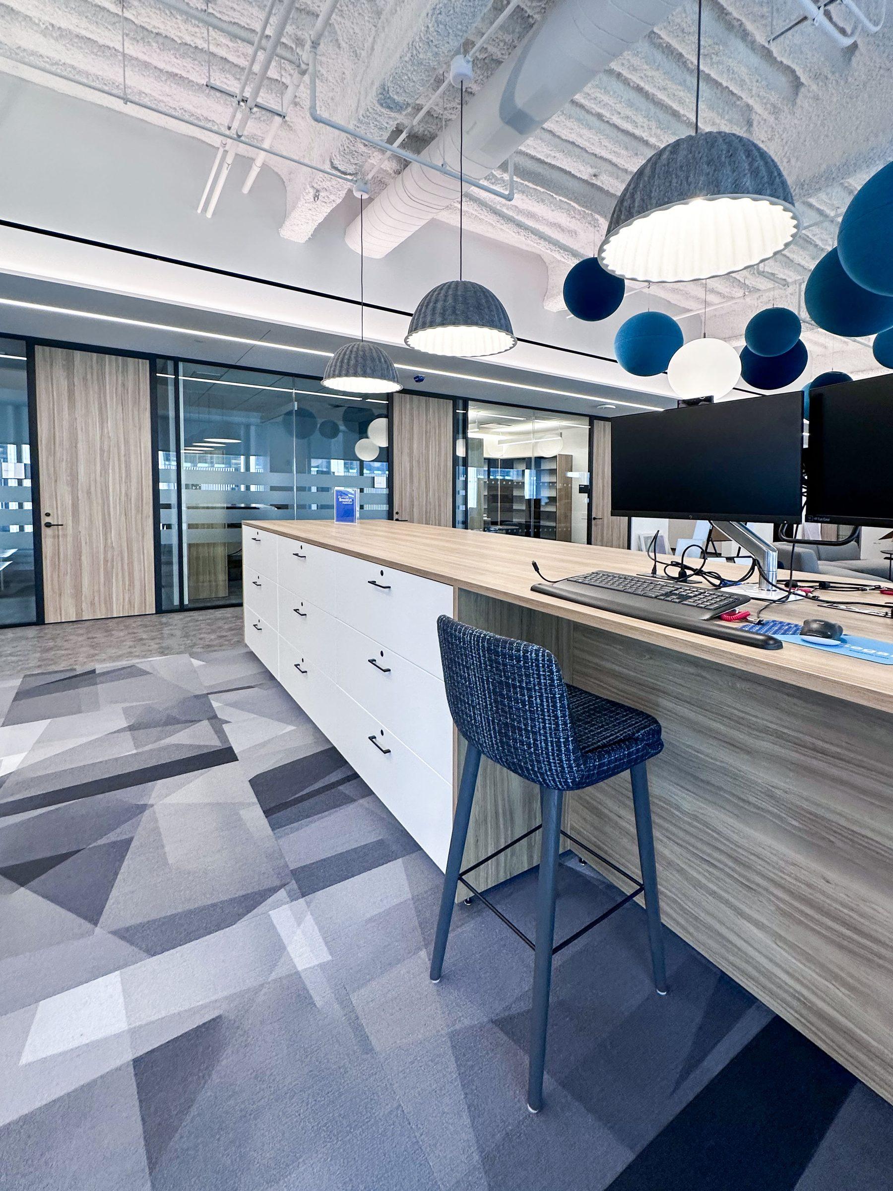 White casework locker island with blue pendant lights in corporate office