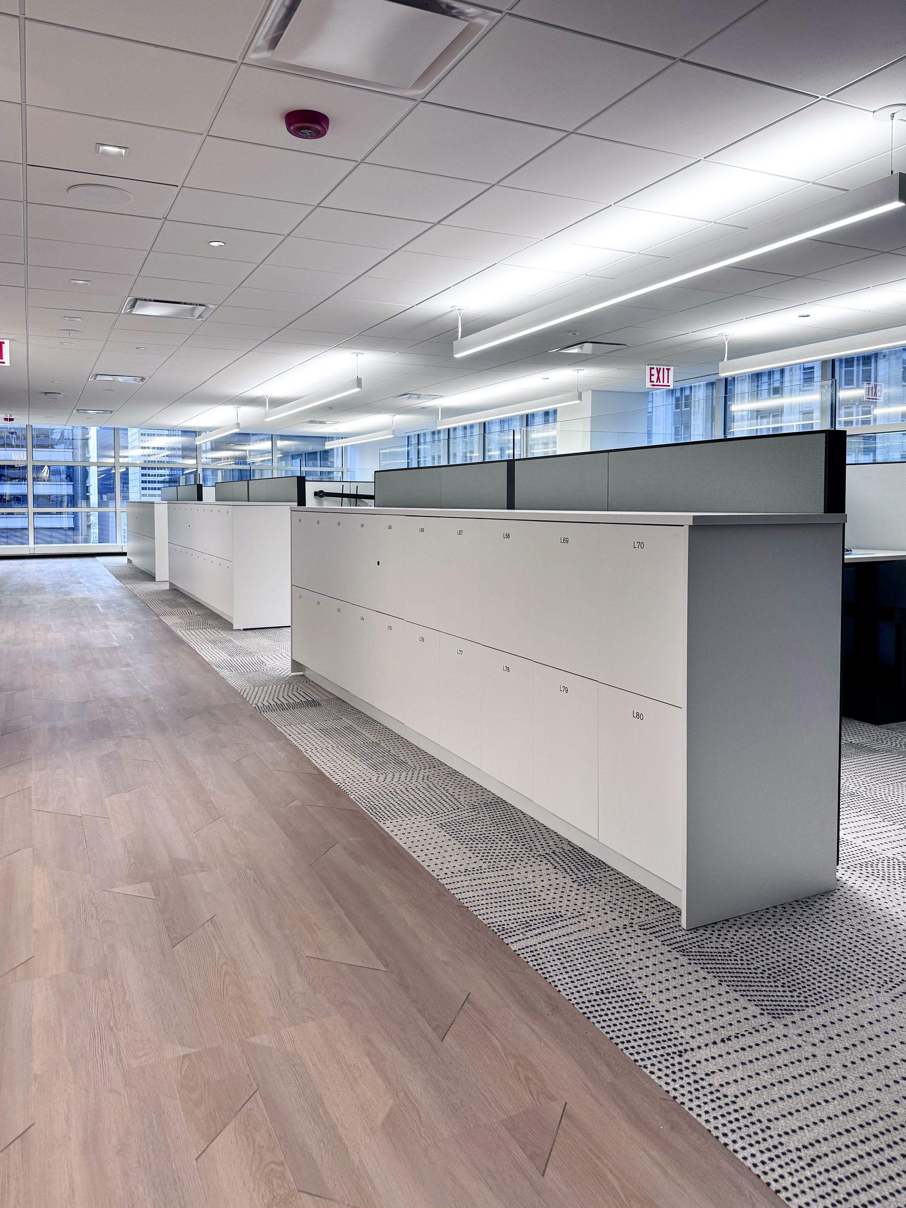 White counter-height end-cap locker banks across open-plan office row