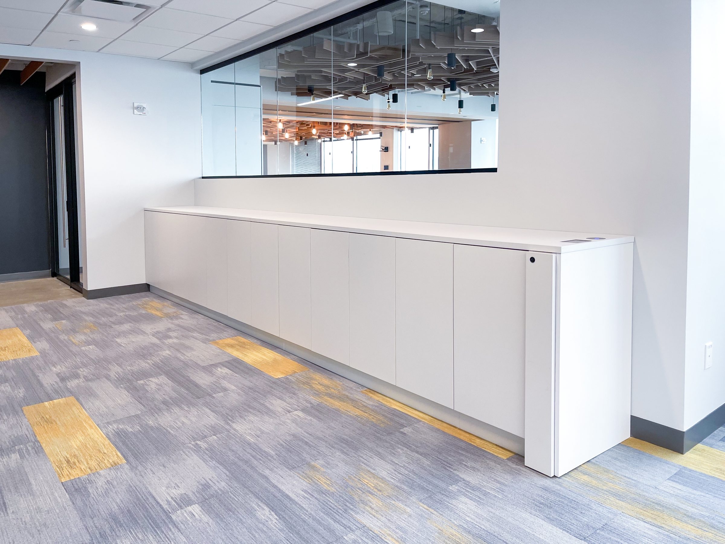White low-profile locker storage integrated under windows — Chubb Insurance Jersey City corporate office