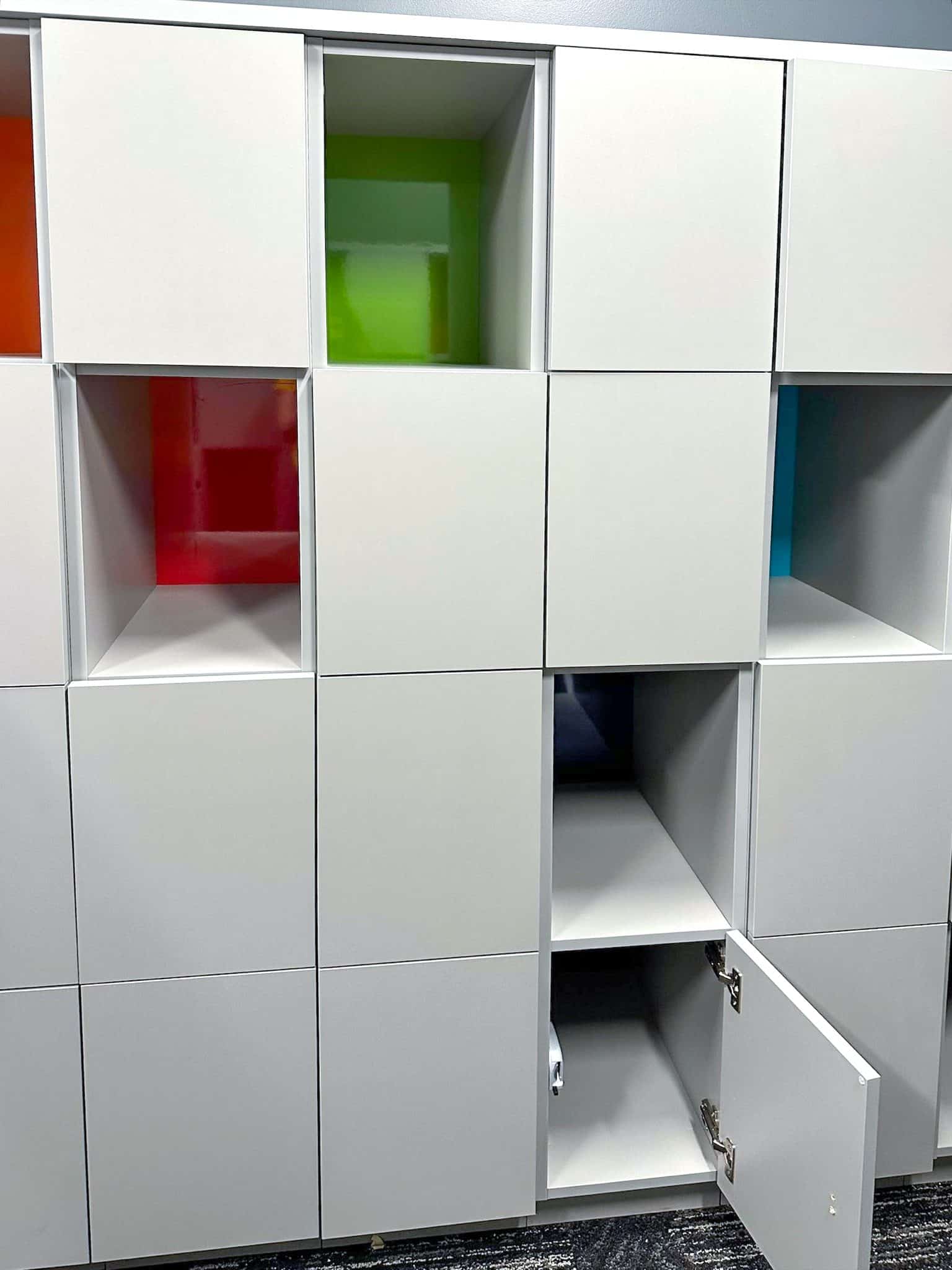 White modular open lockers with colorful acrylic interior panels — HDI NYC office installation