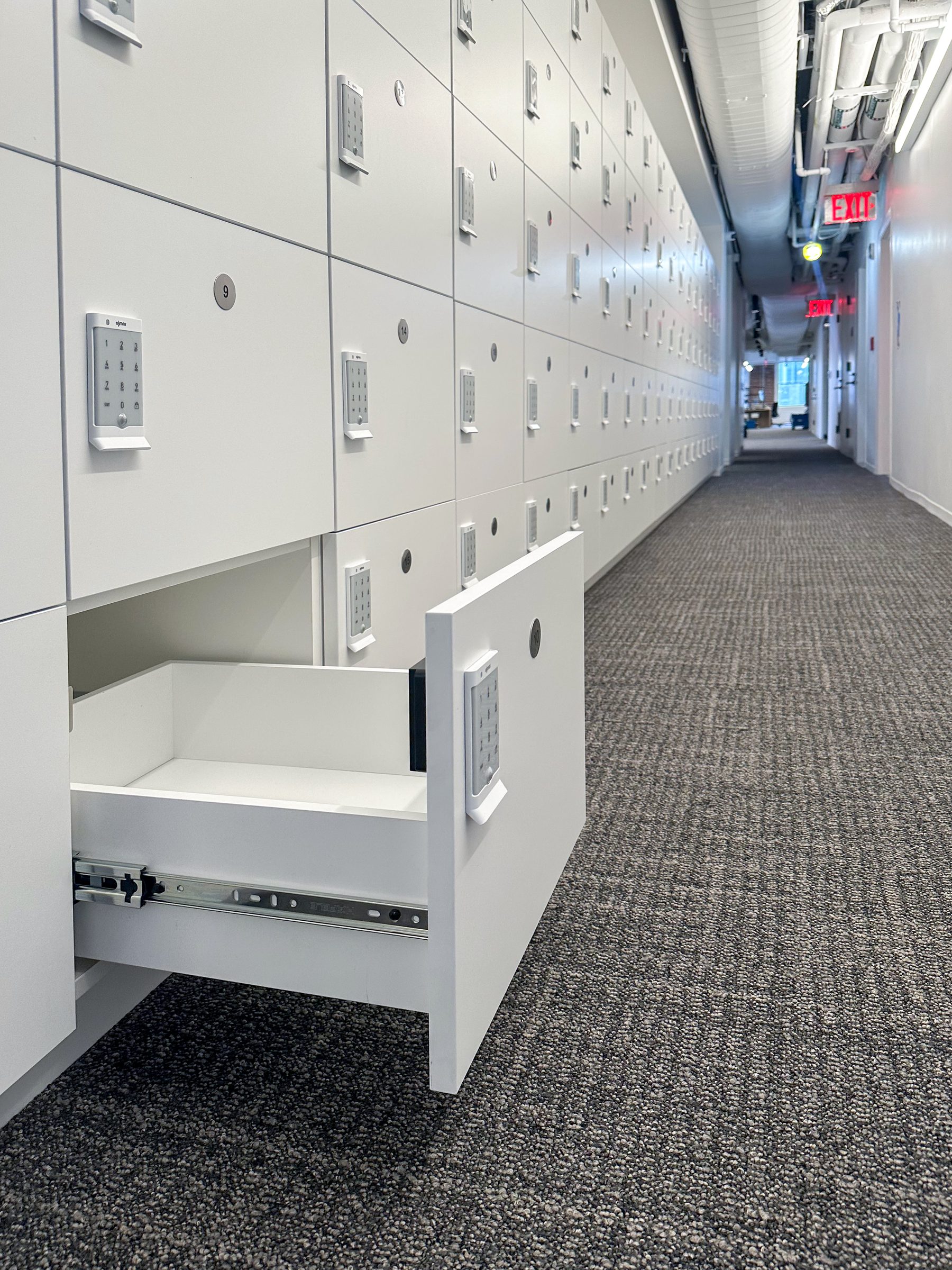 White office locker corridor with open drawer foreground