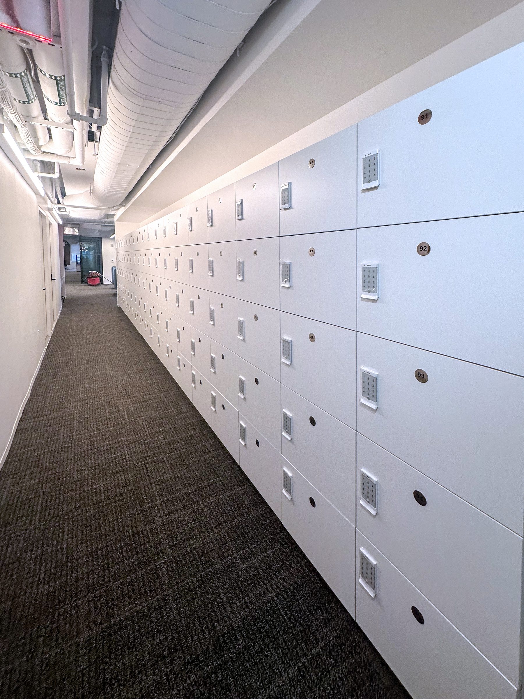 White office locker corridor with PIN keypad — enterprise
