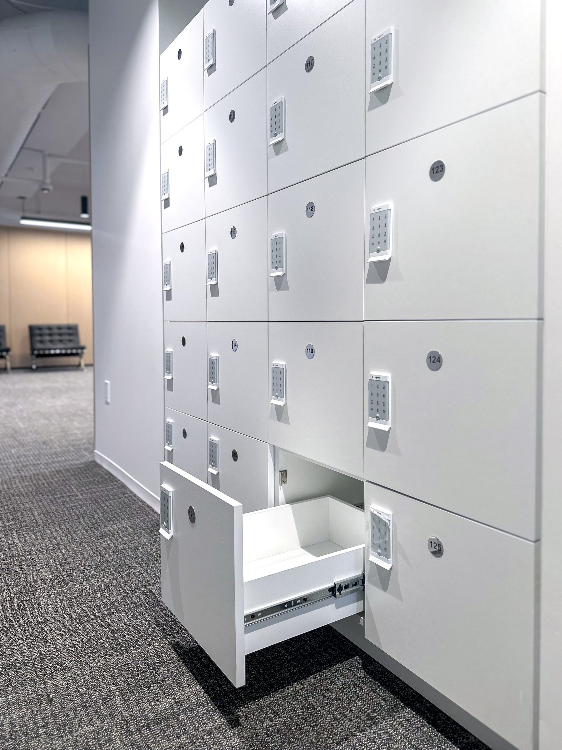White office lockers with open numbered drawer — detail view of storage compartment