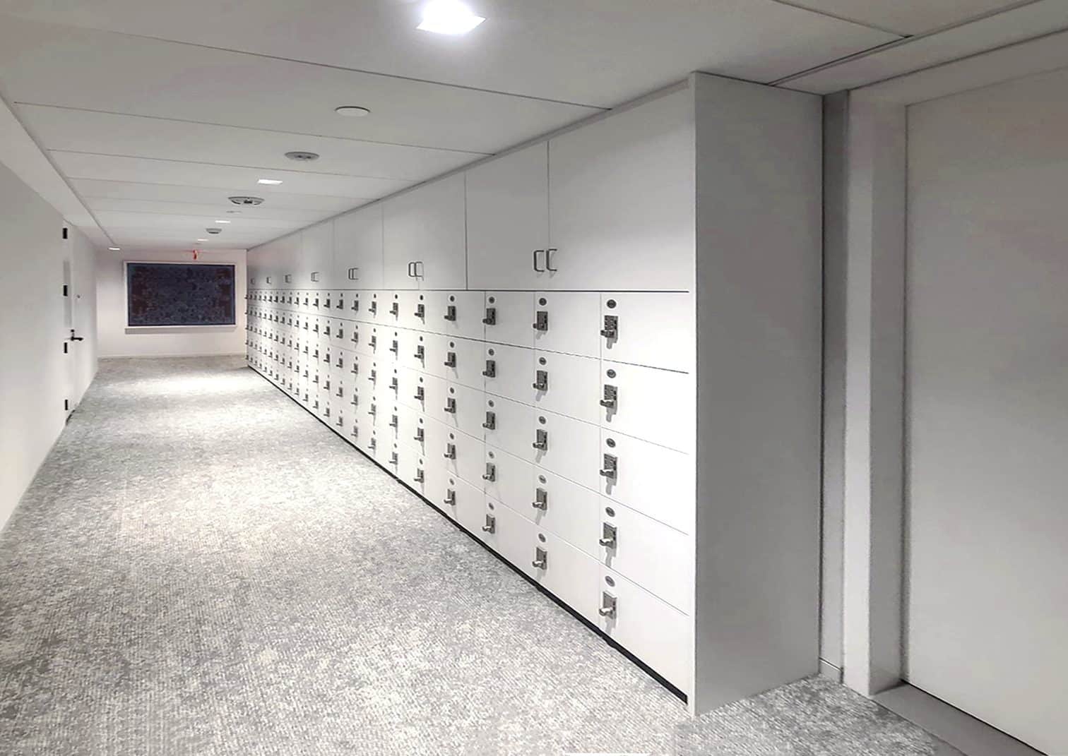 White wall lockers with upper storage cabinets in an enterprise NYC office