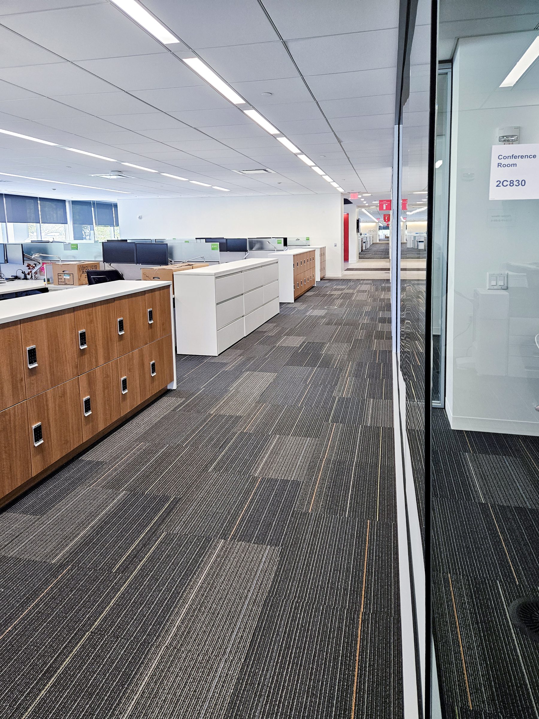 Woodgrain end-cap lockers in open office corridor — AbbVie